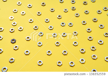 Metal nuts pattern on yellow background Metal nuts pattern on yellow background 138352559