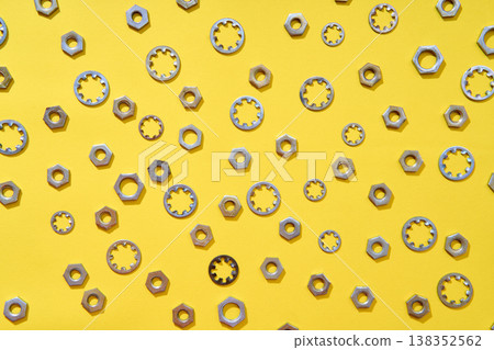 Mixed washers and nuts pattern over yellow background Mixed washers and nuts pattern over yellow background 138352562