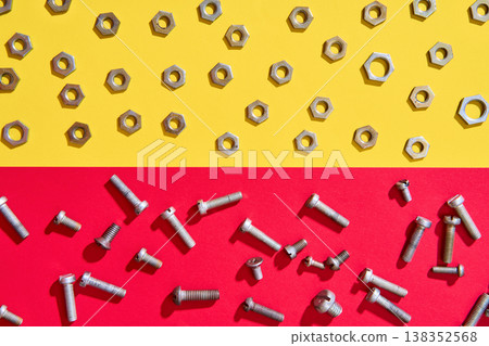Screws and nuts on red yellow background 138352568