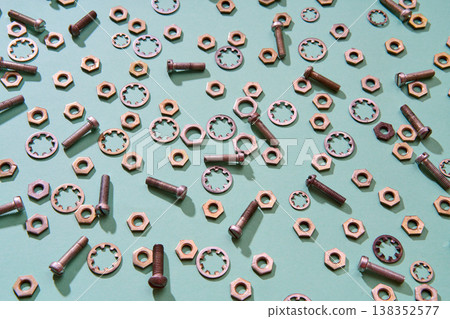 Scattered metal nuts bolts and washers on mint background Scattered metal nuts bolts and washers on mint background 138352577