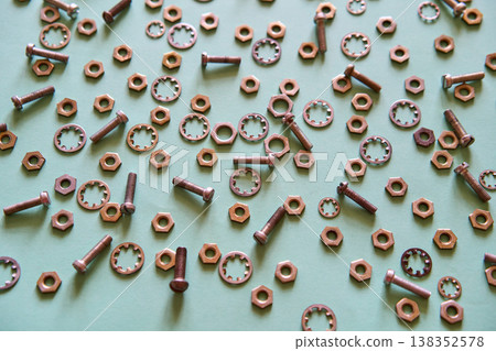 Scattered metal nuts bolts and washers on mint background Scattered metal nuts bolts and washers on mint background 138352578