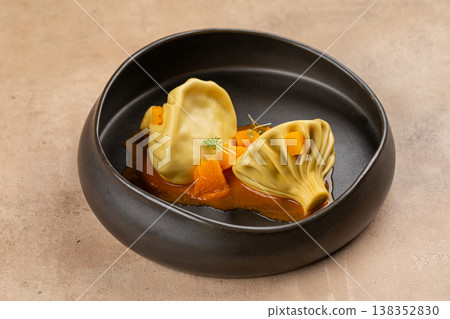 Khinkali dumplings with sauce in black bowl Khinkali dumplings with sauce in black bowl 138352830