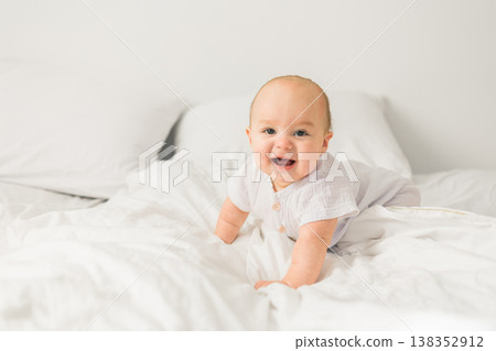 Happy baby lying on bed laughing copy space. Generation alpha and gen alpha Happy baby lying on bed laughing copy space. Generation alpha and gen alpha 138352912