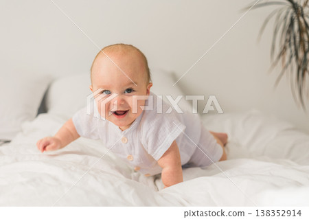 Happy baby lying on bed laughing copy space. Generation alpha and gen alpha Happy baby lying on bed laughing copy space. Generation alpha and gen alpha 138352914