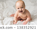 Funny happy newborn baby on a white bed at home, the concept of a happy healthy infant baby. Generation alpha and gen alpha 138352921