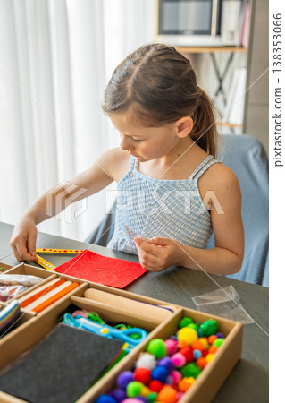 Little girl decorating handmade craft with colorful self adhesive rhinestones at table. Kids creativity fine motor skills development and learning through play concept. Little girl decorating handmade craft with colorful self adhesive rhinestones at table. Kids creativity fine motor skills development and learning through play concept. 138353066