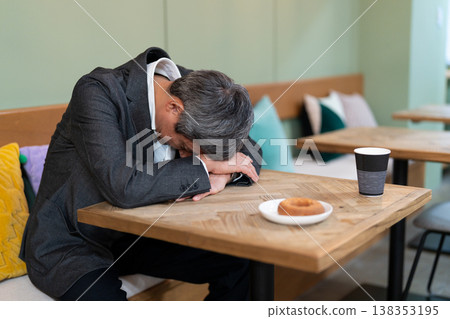 中年男子在休息時間面朝下睡覺。 中年男子在休息時間面朝下睡覺。 138353195