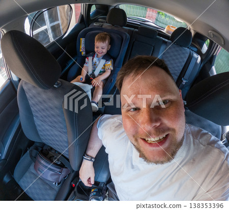 Father selfie with toddler in car seat inside family car Father selfie with toddler in car seat inside family car 138353396