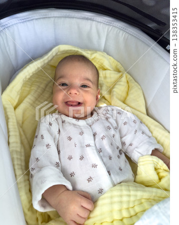 Baby in stroller bassinet with rattle and plush goose Baby in stroller bassinet with rattle and plush goose 138353415