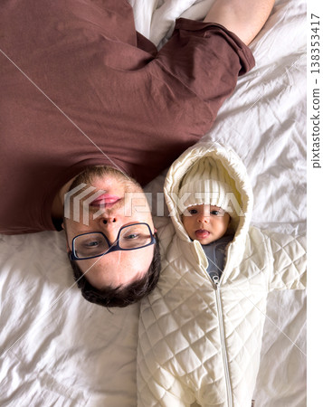 Father and baby bonding on bed in winter outfit Father and baby bonding on bed in winter outfit 138353417
