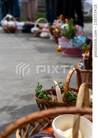 Easter food baskets with candles and flowers at blessing ceremony Easter food baskets with candles and flowers at blessing ceremony 138353418