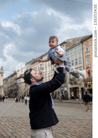 Father lifting toddler in historic european street 138353438