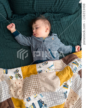 Peaceful sleeping baby under patchwork quilt at home Peaceful sleeping baby under patchwork quilt at home 138353498