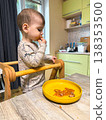 Toddler self-feeding messy meal in high chair 138353500