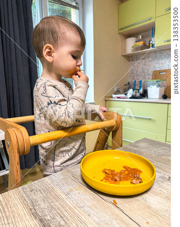Toddler self-feeding messy meal in high chair Toddler self-feeding messy meal in high chair 138353500