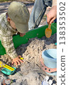 Father and son playing in sandbox outdoors on sunny day 138353502