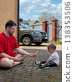 Father and toddler drawing with sidewalk chalk outdoors 138353506