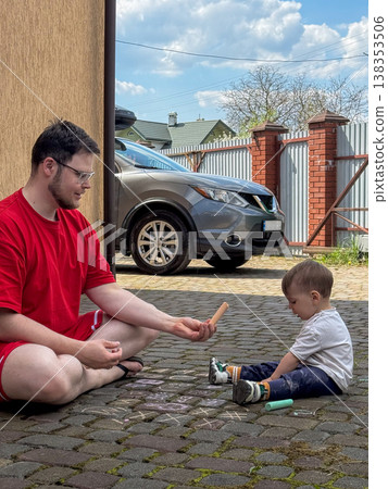 Father and toddler drawing with sidewalk chalk outdoors 138353506