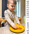 Toddler self-feeding messy meal in high chair 138353508