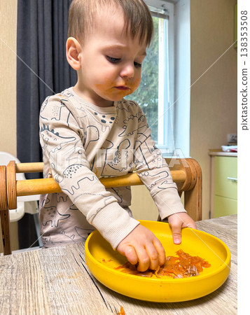 Toddler self-feeding messy meal in high chair 138353508