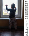 Toddler silhouette reaching toward window at home 138353527