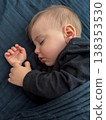 Peaceful sleeping baby on dark blue bedding 138353530