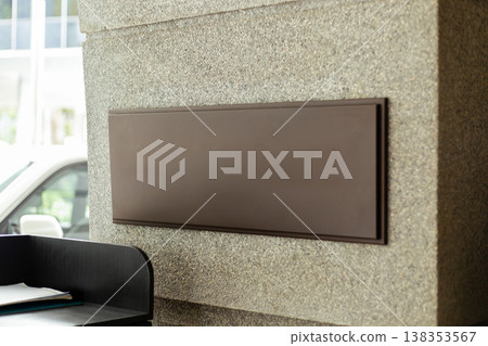 This storefront displays a blank space for branding and advertising. It is situated in a retail area and captures the activity of shoppers during the day. The facade has a simple design 138353567