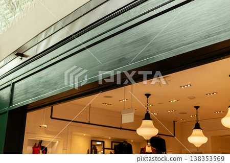 The storefront features a clean design with an empty area for logo placement, suitable for branding. It is located in a busy shopping district with bright lights 138353569