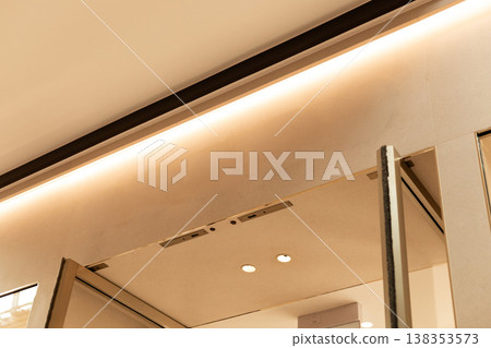 Storefront in a retail area shows an empty space where a logo can be placed. The design features clean lines and a light color scheme. Ideal for various brands and shops 138353573