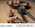 Cracking walnuts with a metal nutcracker tool 138354033