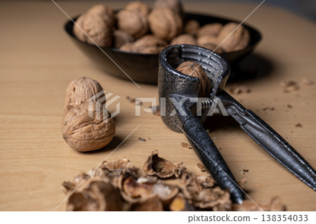 Cracking walnuts with a metal nutcracker tool 138354033