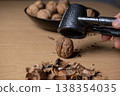 Cracking walnuts with a metal nutcracker tool 138354035