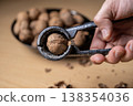 Cracking walnuts with a metal nutcracker tool 138354036