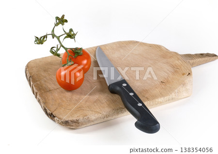 Preparing to slice fresh tomatoes on a wooden chopping board Preparing to slice fresh tomatoes on a wooden chopping board 138354056