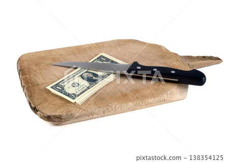 US dollar banknotes and a kitchen knife on a wooden chopping board US dollar banknotes and a kitchen knife on a wooden chopping board 138354125
