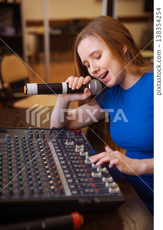 Young woman mixing live sound. Girl recording a song in the studio.  138354254
