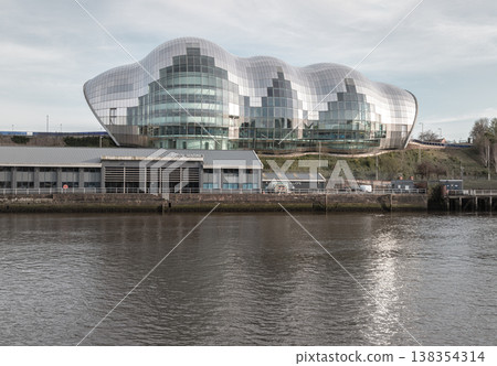 The shimmering, undulating curves of The Glasshouse International Centre for Music (Sage Gateshead) dominate the horizon, its mirrored stainless steel and glass facade reflecting the soft light. This The shimmering, undulating curves of The Glasshouse International Centre for Music (Sage Gateshead) dominate the horizon, its mirrored stainless steel and glass facade reflecting the soft light. This 138354314