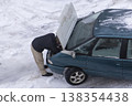 Young man looking under the hood of breakdown car 138354438