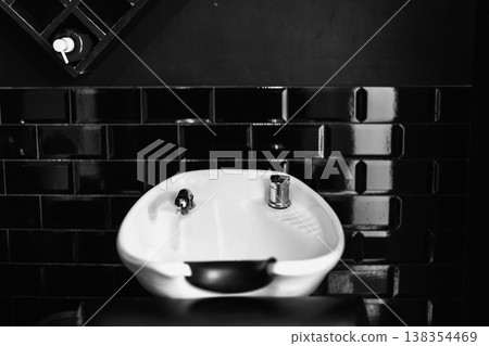 Stylish Wash Station With Glossy Porcelain Basin And Sleek Chrome Fixtures In Modern Salon Setting Stylish Wash Station With Glossy Porcelain Basin And Sleek Chrome Fixtures In Modern Salon Setting 138354469