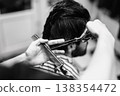 Handson Hair Cutting Training. Young Stylist Learns Hair Trimming Techniques In Lively Salon Setting 138354472