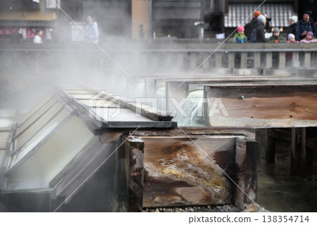 Hot spring water flowing through wooden pipes at the Yubatake hot spring area in Kusatsu Onsen. Hot spring water flowing through wooden pipes at the Yubatake hot spring area in Kusatsu Onsen. 138354714