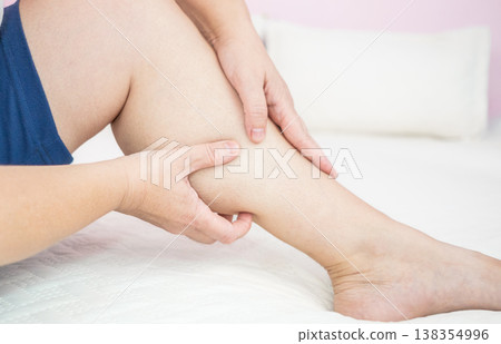 Woman with muscle pain or leg pain, massaging her leg. 138354996