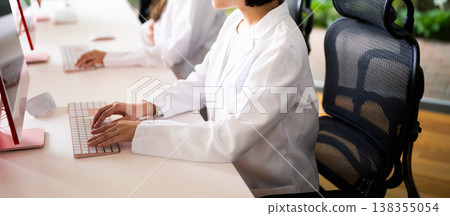 A woman in a white coat enters the data. A woman in a white coat enters the data. 138355054