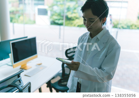 Men in white coats operating tablets Men in white coats operating tablets 138355056