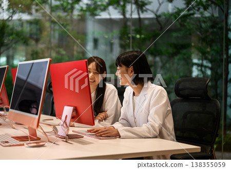 Two women working on a PC Two women working on a PC 138355059