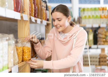 Young woman choosing cornflakes for breakfast Young woman choosing cornflakes for breakfast 138355187