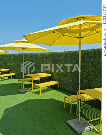 It is an outdoor cafe with parasols. It is an outdoor cafe with parasols. 138355734