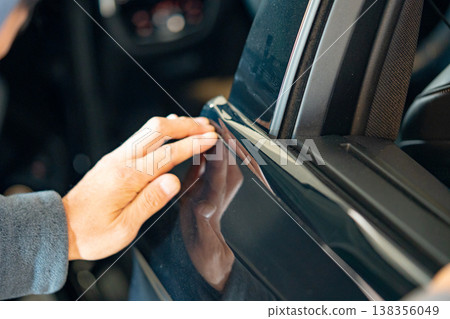 A car wrapping specialist applies a polyurethane film to the car. Detailer PPF 138356049