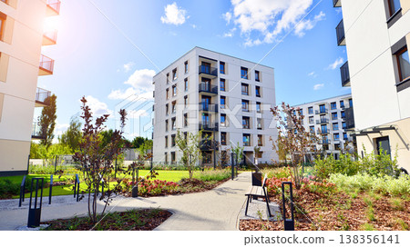 European residential architecture harmonizing with nature. Eco-friendly living in city with greens. Eco apartment building saving energy and fresh air concept.  138356141