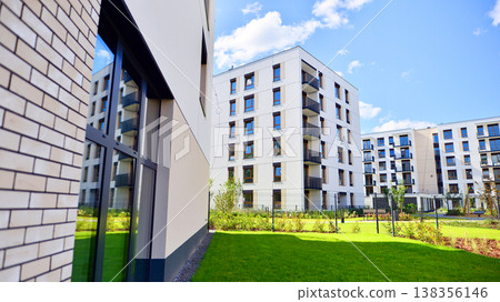 European residential architecture harmonizing with nature. Eco-friendly living in city with greens. Eco apartment building saving energy and fresh air concept. European residential architecture harmonizing with nature. Eco-friendly living in city with greens. Eco apartment building saving energy and fresh air concept. 138356146